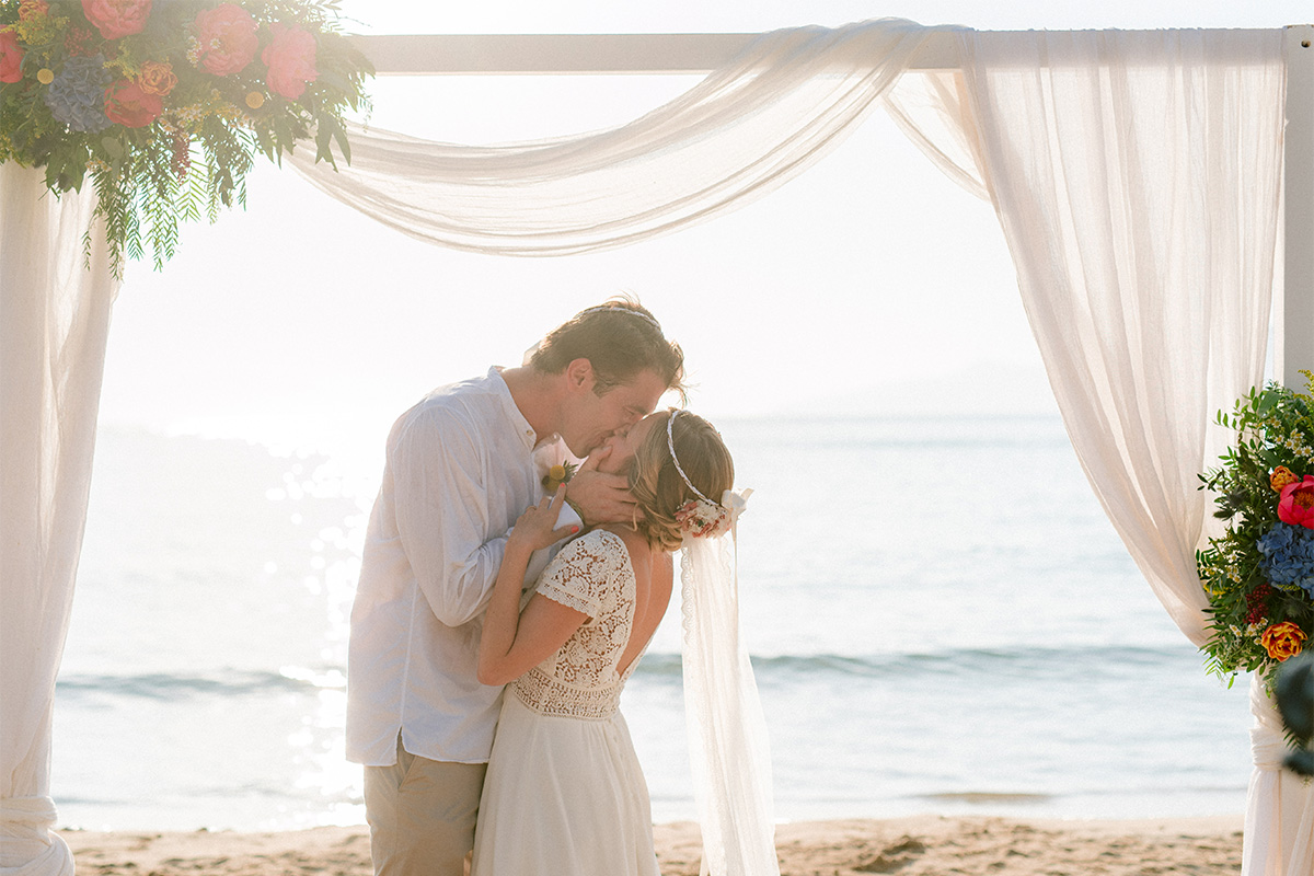 Couple kissing under the wedding arch