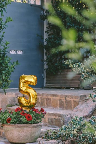 Flower pot on stairs with baloon in the shape of number 5