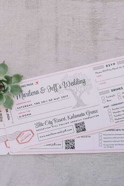 Flight ticket inspired wedding invitation and succulent on a grey background for destination wedding in kalamata.