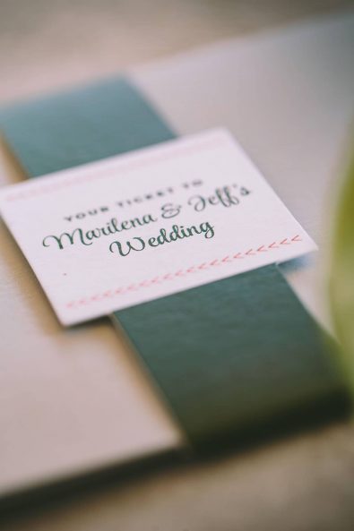 A dark olive green paper ribbon around a wedding invitation cream white envelope for a destination wedding in kalamata.