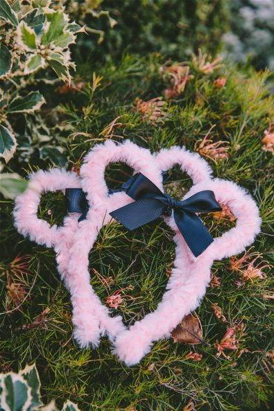 Pink furry Minnie Mouse Party hairbands with black ribbon on grass