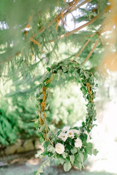 Vine wreath with greenery, lilies, and roses for an intimate summer wedding.