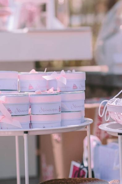 Round custom watermelon printed boxes as christening baptism ceremony favors with pink ribbons.