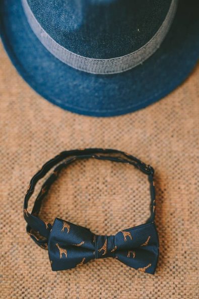 Baby baptism navy blue neck bow tie with blown giraffes and a blue denim hat.