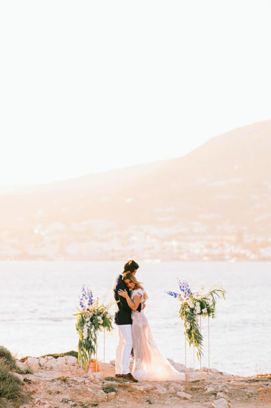 Long distance photo of bride and groom in front of the sea