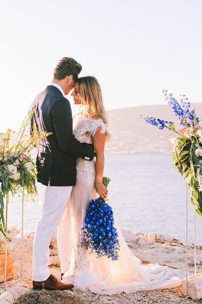 groom hugging the bride in front of sea after the ceremony