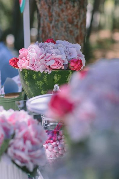 Fresh hydrangea and rose flowers into a carved watermelon bowl.