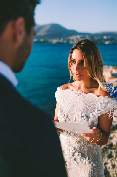 bride reading vows in front of sea