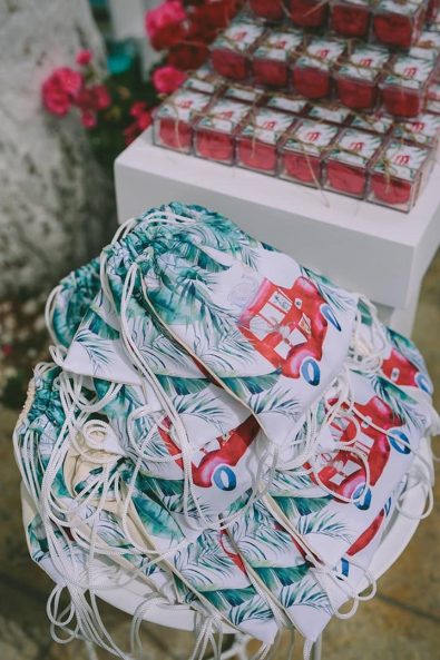 Printed bags with a red bus, jungle animals and green leaves print as baptism favors for a boy's christening.