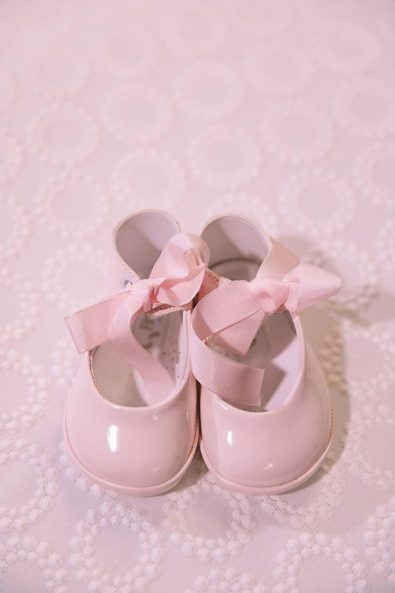 Candy pink patent leather ballet slippers for a baby girl.
