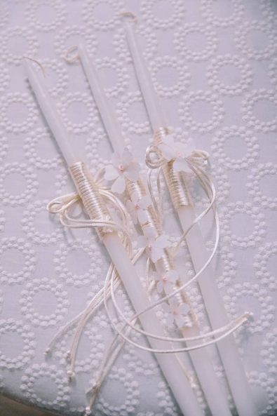 White baptistery candles beautiful baptism ideas decorated with white string and little flowers.
