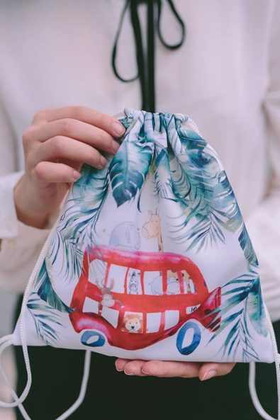 Children's Christening favor bag, with a red bus and leaves printed on it.