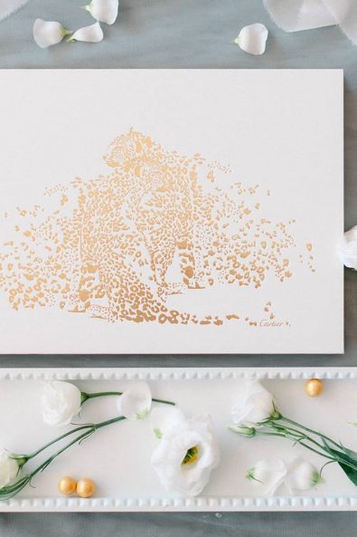 Flatlay shot of white wish box with golden details in a grey background for a minimal and chic wedding.