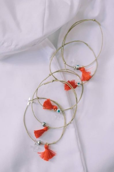 Baptism witness pins martyrika with red tassels and an evil eye.