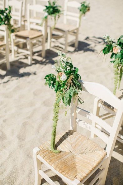 Wooden wedding chair arrangement decorated with flower arrangement with peonies and hypericum berries.