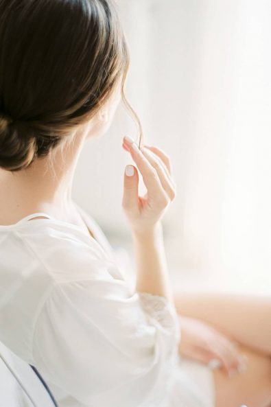 Detail shot of bride wearing a silk white camisole and robe.