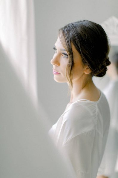 Portrait of the bride with white satin robe and lingerie.