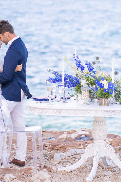 Bride and groom hugging next to the wedding table