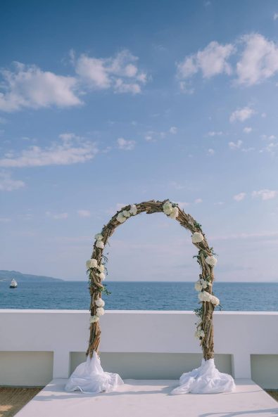 Wedding arch decorated with white hydrangeas for a wedding reception overlooking the sea.