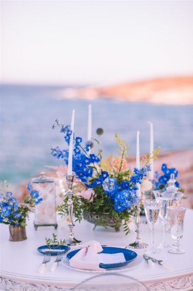 candles flowers and dinnerware on wedding table