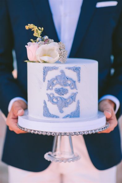 groom holding wedding cake