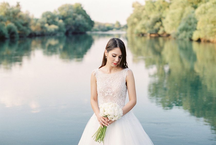 Wedding dresses for Greece showing bride in front of lake