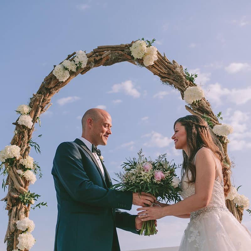 Groom giving his bride the bridal bouquet before their wedding ceremony.