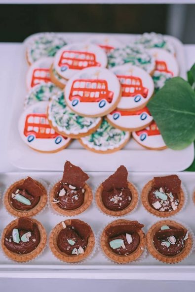 boy baptism sweets with chocolate filling crushed almonds and sugar biscuits with a red bus, jungle animals and green leaves printed sugar paste.