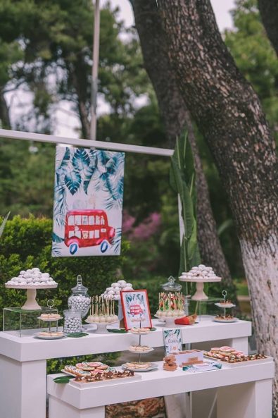 Baptism after party candy bar with sweet treats, macarons, biscuits, cake pops, almond cookies, and koufeta.