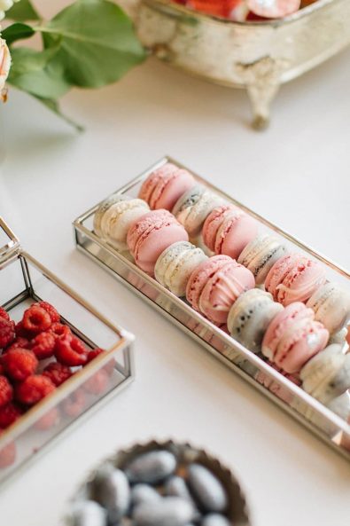 Pastel colored macarons in a silver gilded mirror tray.