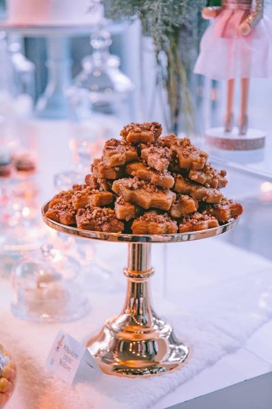 Hand made greek Christmas cookies melomakarona with cinnamon, walnuts, and honey on a gold serving tray.
