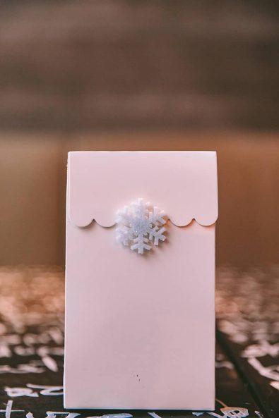 Light pink party gift bag favor with snowflake sticker.