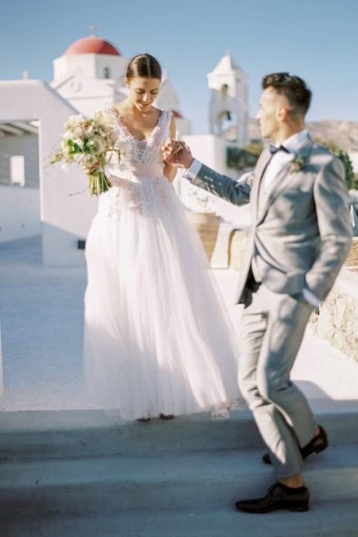 Bride and Groom couple laughing and holding hands in a destination wedding in Greece.