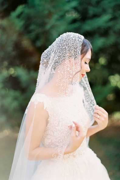 Portrait of a bride wearing her romantic tulle wedding dress and crystal embellished.
