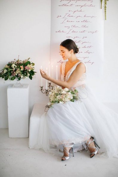FIne art wedding inspiration with a minimal and romantic bride, candles and poem in calligraphy.