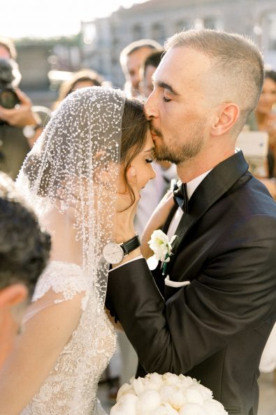 Groom kissing bride on the forehead