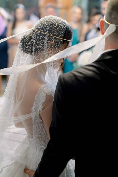 Bride and groom getting married in church wearing their minimal and chic wedding crowns for a Greek Orthodox wedding.