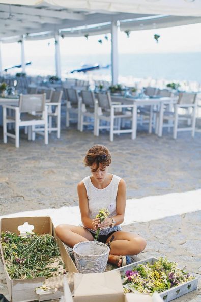 A florist tying flowers for the table flower arrangements.