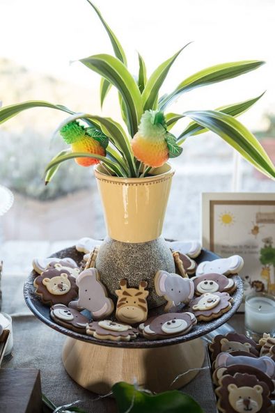 Sugar paste covered butter biscuits shaped like monkeys, elephants, and giraffes at a boy baptism party.