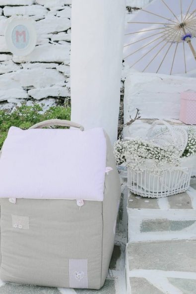 Event decoration with little house shaped clothes bag, basket with white baby's breath flowers and christening favors.