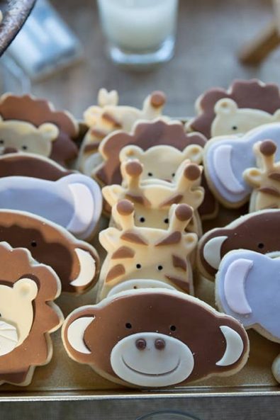 Butter cookies with sugar paste shaped like lions, monkeys, giraffes, and elephants for a boy baptism.