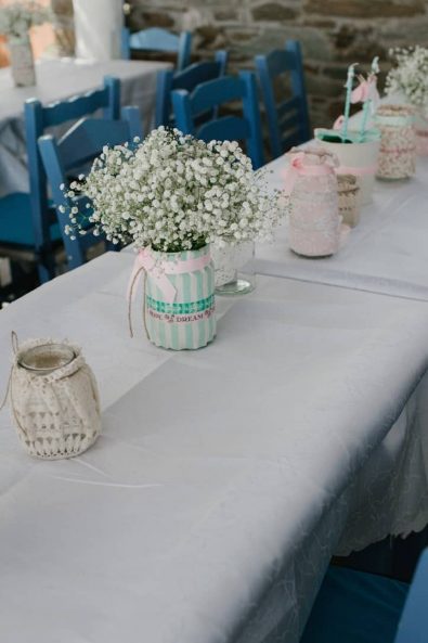 Dinner centerpieces with custom made candle lanterns and wase with white flowers.