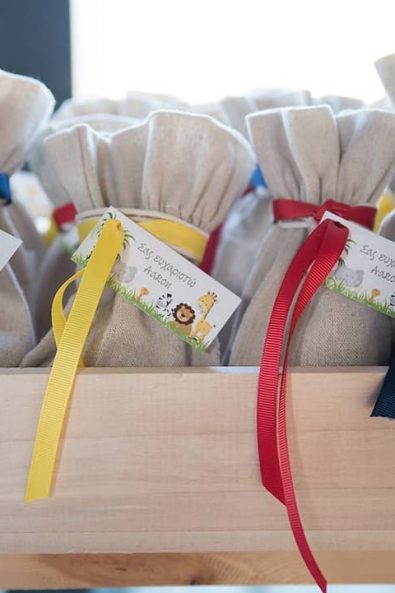 Close up shot of boy baptism favors with burlap bags and blue, yellow and red ribbons.