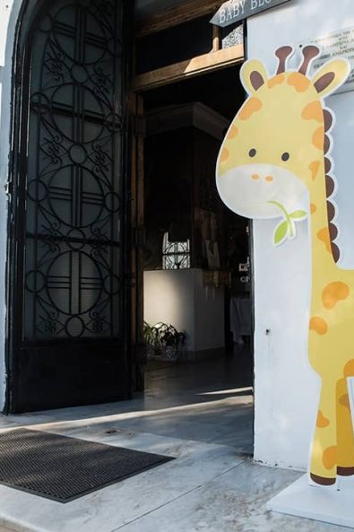 Church entrance decorations with giraffe and pine tree.