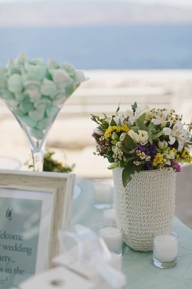 Wedding flower arrangement with alstroemeria, daphne leaves, roses, and colorful wildflowers.