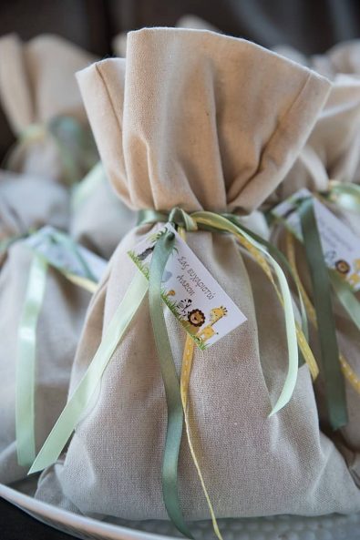 Christening favors with a burlap bag and olive green, pistachio green, and yellow ribbons for a boy baptism.