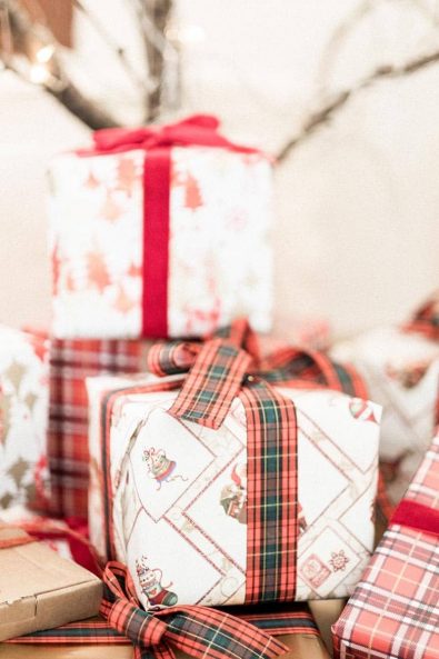 Festive present wrapping with tartan red and green ribbon and traditional white and red wrapping paper.