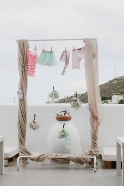 Landry inspired baptism christening ideas decoration with hanging dresses and baby clothes in Kythnos Island.