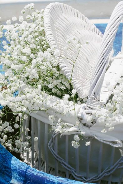 White baby's breath flower arrangement in a white basket.