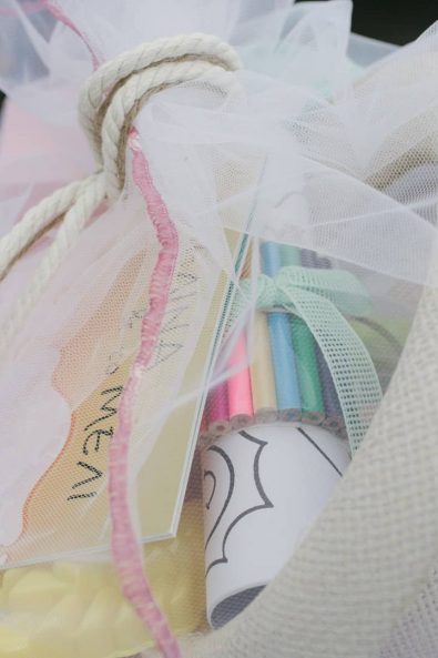 Kids' party christening ideas favors with coloring pencils, coloring books, and a straw hat.